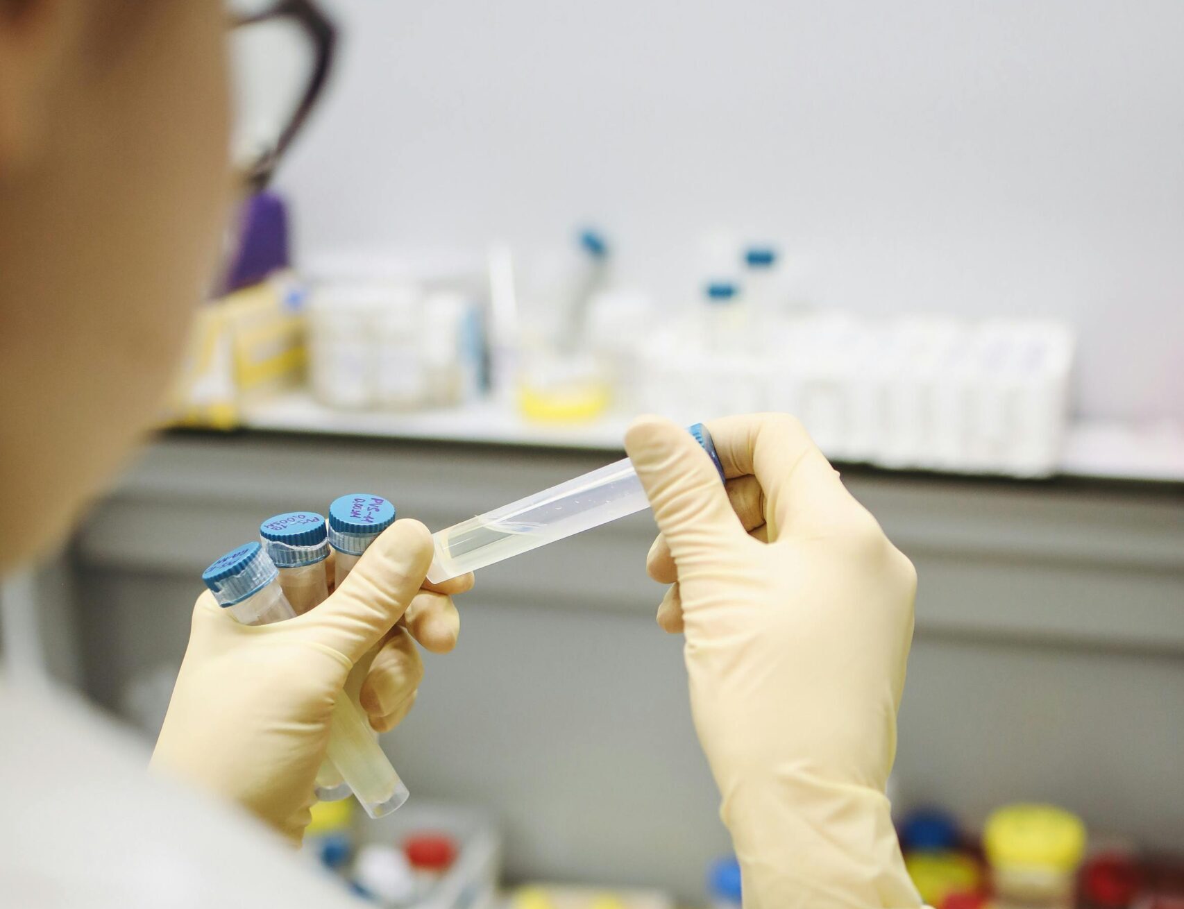 Scientist in lab holding test tube for COVID-19 research, indoors.